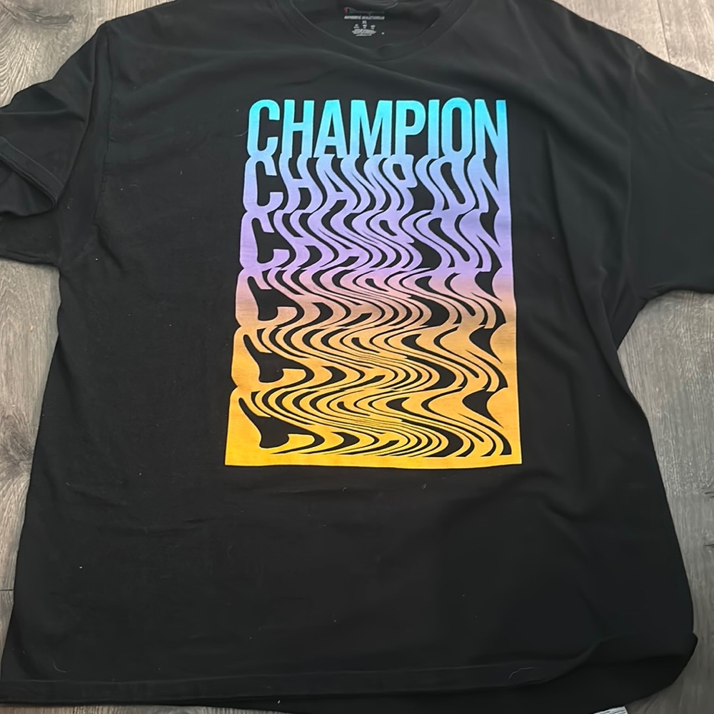 A black tee shirt from champion with a cool looking design
